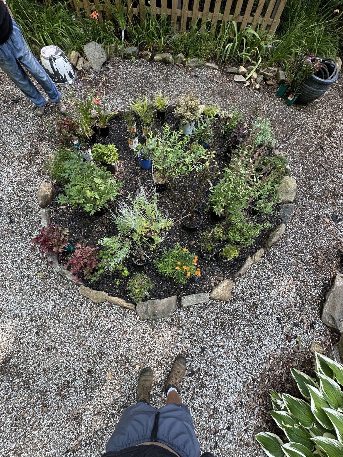 Freshly planted circular garden bed with stone border, laid out and ready to fill in